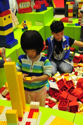 小朋友沉浸在樂高積木的世界里，專心致志地拼搭自己的作品。